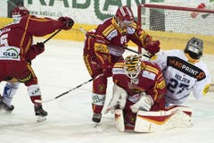 Die Langnauer Kevin Hecquefeuille, (mitte links) und Goalie Damiano Ciaccio machen Zugs Josh Holden das Spiel schwer. (Bild: Keystone / Marcel Bieri)