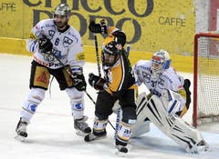 Die Zuger Tim Ramhol (links) und Eero Kilpeläinen (rechts) gegen Luganos Sebastien Reuille. (Bild: Keystone)