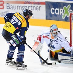 Peter Guggisberg (links) schiebt mit dem 22. Penalty den Puck zwischen den Schonern von EVZ-Torhüter Tobias Stephan hindurch und entscheidet das spektakuläre Penaltyschiessen für sich. (Bild: Keystone / Gabriele Putzu)