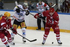 Die Lausanner Juha Pekka Hytonen (links) und Damien Fleury (rechts) verteidigen den Puck gegen den Zuger Santeri Alatalo (mitte), welcher den Stock zu hoch hält. (Bild: Keystone / Maxime Schmid)