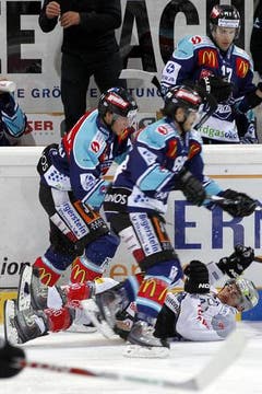Der Zuger Fabian Schnyder (unten) wird von den Lakers Andreas Camenzind (links) und Aurelio Lemm übersprungen. (Bild: Keystone)