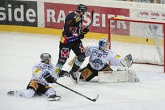 Der Berner Mikko Lehtonen (Mitte) beschaeftigt die Zuger Yannick Blaser (links) und Goalie Eero Kilpelainen. (Bild: Keystone / Peter Schneider)