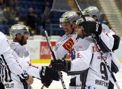 Die Spieler des EV Zug Glen Metropolit, Alessandro Chiesa, Thomas Ruefenacht und Andy Wozniewski, verdeckt, feiern einen Treffer. (Bild: Keystone)