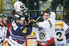 Da fliegen die Fetzen: Zugs Santeri Alatalo (links) im Kampf gegen Luganos Julian Walker. (Bild: Keystone / Alexandra Wey)