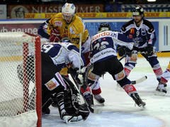 Claudio Moggi von den Tigers, hinten, scheitert an Goalie Sandro Zurkirchen, Samuel Erni und Thomas Ruefenacht vom EV Zug. (Bild: Keystone)