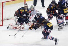 Der Zuger Andy Wozniewski, Mitte, kämpft um den Puck mit Berns Jean-Pierre Vigier und Torhüter Olivier Gigon.