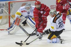 Der Zuger Goalie Tobias Stephan sowie der Zuger Spieler Santeri Alatalo (rechts) kämpfen um den Puck gegen den Lausanner Benjamin Antonietti. (Bild: Keystone / Jean-Christophe Bott)