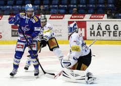 Kloten Flyers Stuermer Cyrill Buehler, von links, gegen EV Zug Stuermer Fabian Sutter und Torhueter Eero Kilpelainen. (Bild: Keystone)