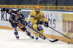 Der Zuger Dominik Schlumpf (links) kämpft um den Puck gegen den Davoser Mauro Joerg. (Bild: Keystone / Alexandra Wey)