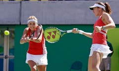 Timea Bacsinszky (links) und Martina Hingis gehen beide auf den Ball los. (Bild: AP Photo/Charles Krupa)