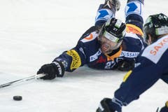 Josh Holden am Boden – aber nicht am Ende: Er streckt sich nach dem Puck. (Bild: Keystone / Urs Flüeler)