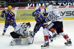 Kloten Flyers Stürmer Simon Bodenmann, Mitte, gegen EV Zug Torhüter Sandro Zurkirchen.