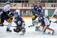Mauro Dufner (Biel, mitte) und Goalie Lukas Meili rechts, kämpfen gegen Nicolas Thibaudeau (EVZ, links) um den Puck. (Bild: Keystone / Marcel Bieri)