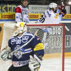 Goalie Michael Tobler vom EV Zug ist geschlagen; Michael Ngoy von Fribourg jubelt. (Bild: Keystone)