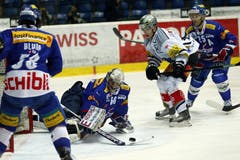 Kloten Flyers -Goalie Ronnie Rüegerversucht die Scheibe vor dem Zuger Stürmer Reto Suri zu sichern.