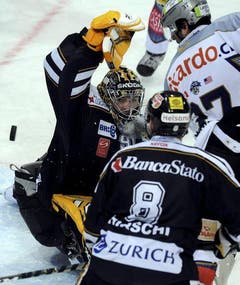 Andy Wozniewski, rechts, vor dem Lugano Tor von Benjamin Conz und Steve Hirschi. (Bild: Keystone)