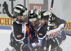 Andy Wozniewski, Damien Brunner (Torschütze) und Fabian Schnyder (von links) feiern das 4:3 in der Overtime. (Bild: Keystone/Urs Flüeler)
