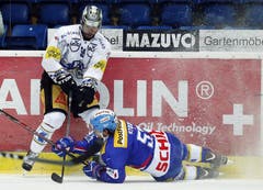 EV Zug Stuermer Robbie Earl, stehend, gegen Kloten Flyers Verteidiger Lukas Stoop. (Bild: Keystone)