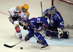 Duri Camichel (links) kämpft gegen Zürichs Severin Blindenbacher um den Puck - vor Goalie Ari Sulander. (Bild: Steffen Schmidt/Keystone)