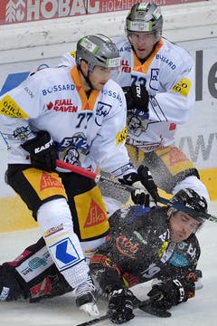 Der Berner Chuk Kobasew, am Boden, und die Zuger, Robin Grossman und Samuel Erni, von links, kämpfen um den Puck im Eishockey-Meisterschaftsspiel der National League A zwischen dem SC Bern und dem EV Zug am Freitag in der PostFinance-Arena in Bern. (Bild: Keystone/Lukas Lehmann)