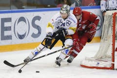 Der Zuger Andrew Hutchinson (links) schirmt den Puck gegen den Lausanner Simon Fischer ab. (Bild: Keystone)