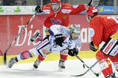 Trifft im Fallen den Puck: Zugs Björn Christen. (Bild: Keystone)
