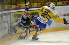 Ein Zuger Spieler wird weggeräumt von Lukas Sieber vom HC Davos. (Bild: Keystone)