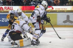 Gerangel um den Puck: Der Zuger Stürmer Pierre-Marc Bouchard, Lugano Goalie Elvis Merzlikins, Lugano Verteidiger Julien Vauclair und Lugano Stürmer Raffaele Sannitz (von links). (Bild: Keystone / Alexandra Wey)