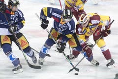 Zugs Josh Holden (Mitte) kämpft gegen Daniel Rubin (rechts) von Servette um den Puck. (Bild: Urs Flüeler / Keystone)