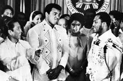 Der philippinische Präsident Ferdinand Marcos (links) applaudiert während Boxer Joe Frazier (rechts) über den Schwergewichtsweltmeister Muhammad Ali (Mitte) spricht. (Bild: Keystone)