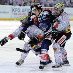 Corsin Casutt im «Sandwich» zwischen Clarence Kparghai, links, und Marc Grieder. (Bild: Keystone)