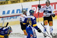 Davos-Torhüter Leonardo Genoni ist bezwungen am Boden gegen Nico Dünner (zweiter von links) und Sandro Zangger. (Bild: Keystone)