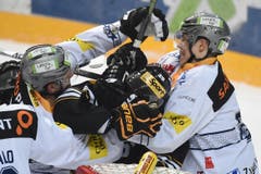 Die Zuger Reto Suri (rechts) und Yannick Blaser (links) im Faustkampf mit Luganos Maxim Lapierre. (Bild: Keystone/Ti-Press/Gabriele Putzu)