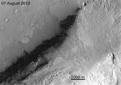 Dieses Bild des Satelliten Mars Reconnaissance Orbiter zeigen die Landestelle von«Curiosity». Die dunklen Stellen am linken Bildrand, westlich des dunklen Dünenfeldes, zeigen sowohl den Rover als auch die Marschstufe, den Fallschirm und das Hitzeschild. Die Auflösung dieser Aufnahme beträgt sechs Meter per Pixel. (Bild: Nasa / JPL-Caltech / MSSS)