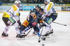 Zugs Sven Senteler enteilt den Ambri-Spielern Adam Hall und Adrien Lauper (rechts) . (Bild: Alexandra Wey / Keystone)