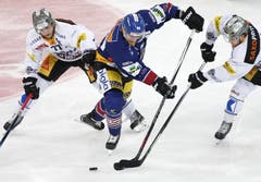 Die Zuger Robin Grossmann (links) und Dominic Lammer (rechts) nehmen den Bieler David Moss in die Zange. (Bild: Keystone / Thomas Hodel)