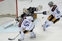 Zugs Fabian Schnyder, links, und Sven Senteler vor Lugano-Goalie Elvis Merzlikins. (Bild: Keystone/Samuel Golay)