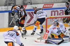 Luganos Tony Martensson (hinten links) kurvt an Robin Grossmann vorbei, nicht aber an Zug-Torhüter Tobias Stephan (rechts). (Bild: Samuel Golay / Keystone)