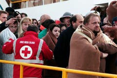 Mitarbeiter des Italienischen Roten Kreuzes versorgen die gestrandeten Passagiere mit Wolldecken. (Bild: Keystone / AP)