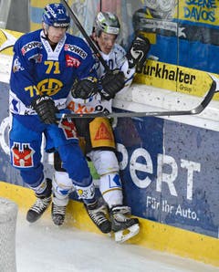 Der Davoser Claude-Curdin Paschoud (links) checkt den Zuger Yannick Blaser an die Bande. (Bild: Keystone / Juergen Staiger)