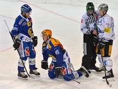Der Davoser Marcus Paulsson (SWE), Mitte schmerzverzerrt am Boden, daneben der Davoser Reto von Arx, links, und rechts der Zuger Enzo Corvi. (Bild: Keystone)