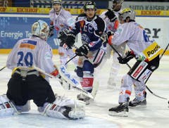 Sven Lindemann vom EV Zug, Mitte, gegen Goalie Reto Berra und Marc Wieser. (Bild: Keystone)
