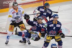 Manuel Gossweiler, Thomas Wellinger und Goalie Lukas Meili (alle Biel, von rechts) weibeln gegen Reto Suri (EVZ) (Bild: Keystone / Marcel Bieri)