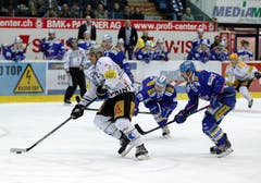 EV Zug Verteidiger Alessandro Chiesa, links, gegen Kloten Flyers Verteidiger Lukas Stoop, Mitte, und Romano Lemm, rechts. (Bild: Keystone)