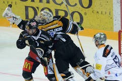 Luganos Goalie Elvis Merzlikins (Mitte) greift nach dem Puck. (Bild: Keystone/Ti-Press/Samuel Golay)
