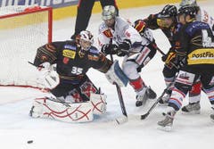 Der Zuger Andy Wozniewski, Mitte, kämpft um den Puck mit Berns Dominic Meier (4), rechts, Beat Gerber (2) und Torhüter Olivier Gigon.