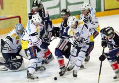 Marc Schulthess, Mitte links, und Roman Botta, Mitte rechts, von Ambri, im Spiel gegen Fabian Schnyder.