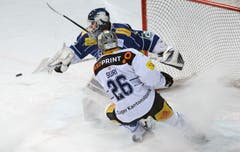 Zugs Reto Suri (rechts) im Zweikampf gegen Ambri-Torhüter Sandro Zurkirchen. (Bild: Keystone / Samuel Golay)