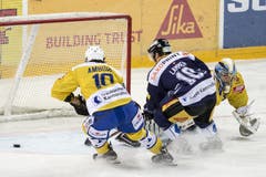 Der Zuger Dominic Lammer (Mitte) kämpft um den Puck gegen die Davoser Andres Ambuehl (links) und Torhüter Leonardo Genoni. (Bild: Keystone / Alexandra Wey)