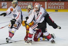 Linesmen Roger Bürgi trennt mit einem Hechtsprung die Streithähne Simon Moser (unten) und Timo Helbling. (Bild: Keystone)